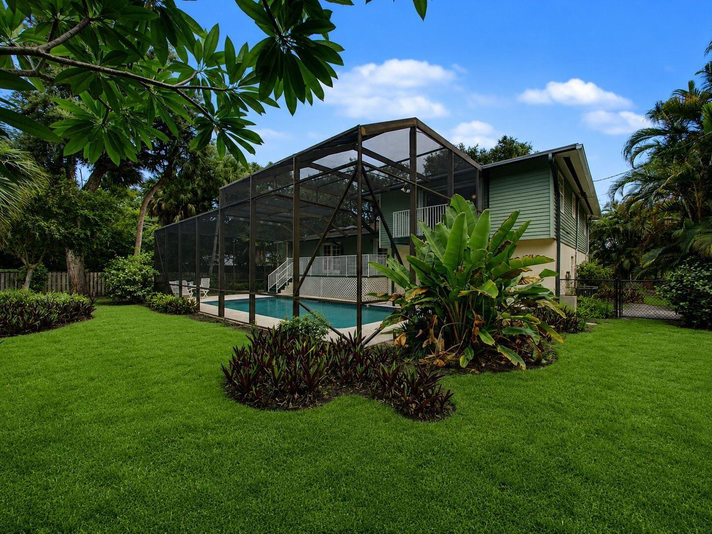 A backyard features a swimming pool enclosed by a screen cage next to a house — 14 Emarita Way, Sewalls Point FL 34996, SEWALLS POINT, FL