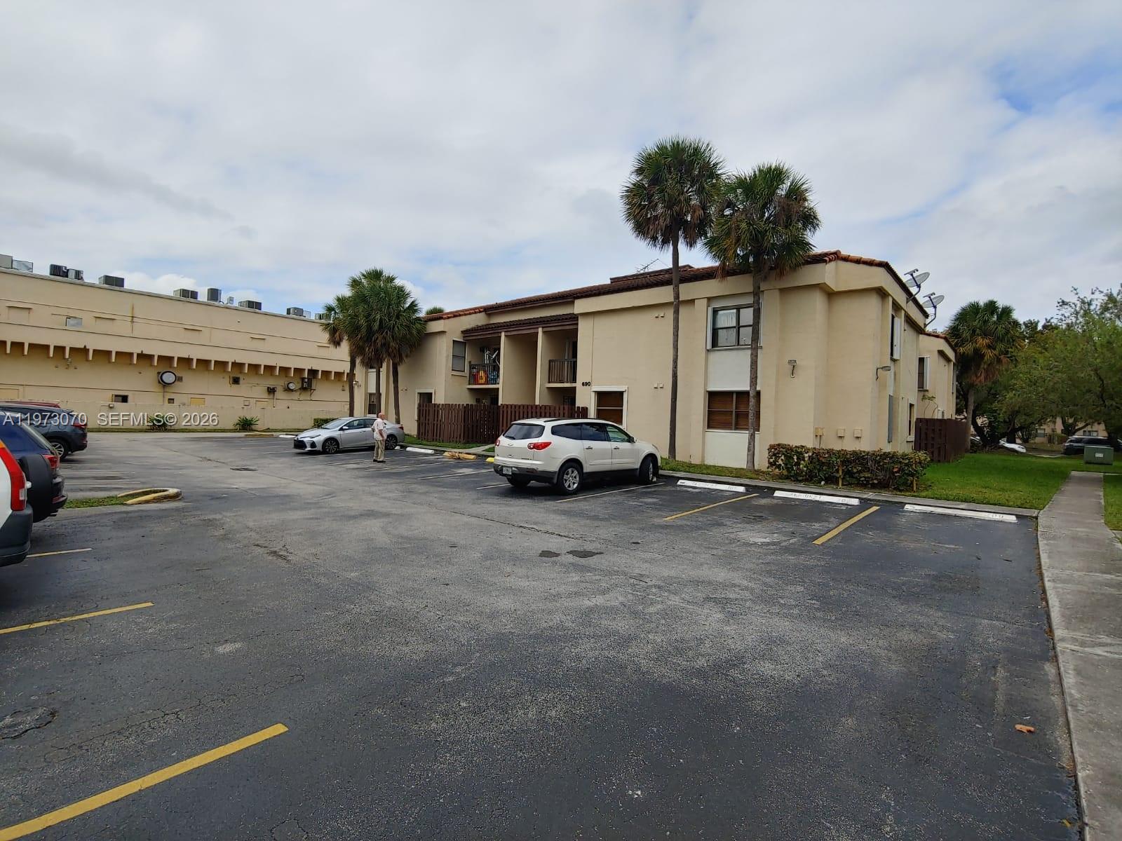 A two-story apartment building with a parking lot and palm trees in front — 690 W Park Dr # 204, Miami FL 33172, MIAMI, FL