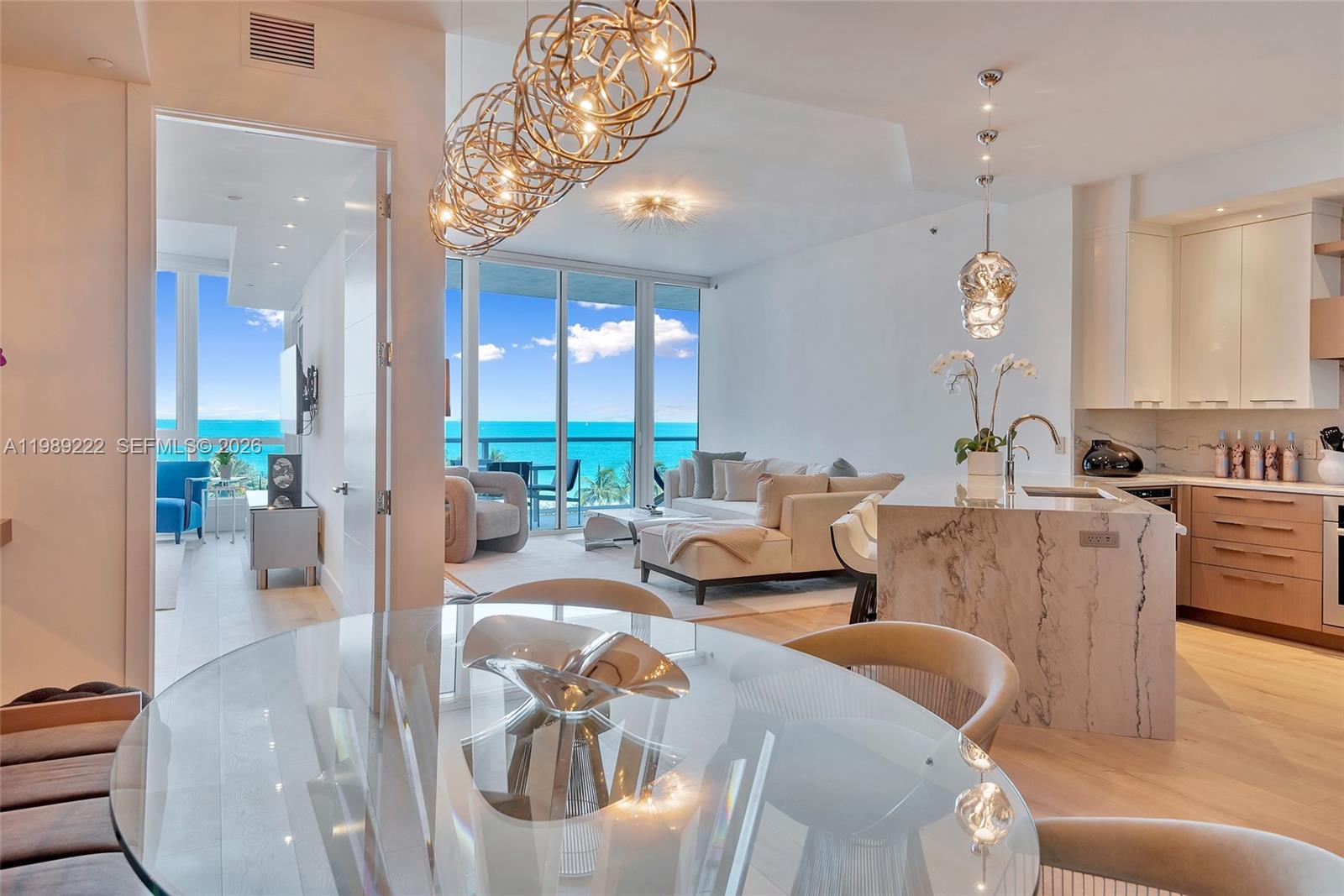 A modern open-concept living area features a kitchen, dining space, and ocean views — 100 S Pointe Dr # 708, Miami Beach FL 33139, MIAMI BEACH, FL