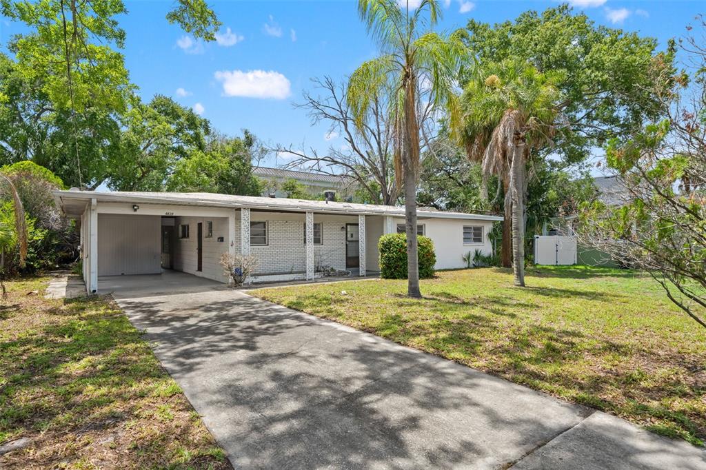 A single-story house with a carport, white brick facade, and a concrete driveway — 4635 W BAY VILLA AVENUE, TAMPA, FL