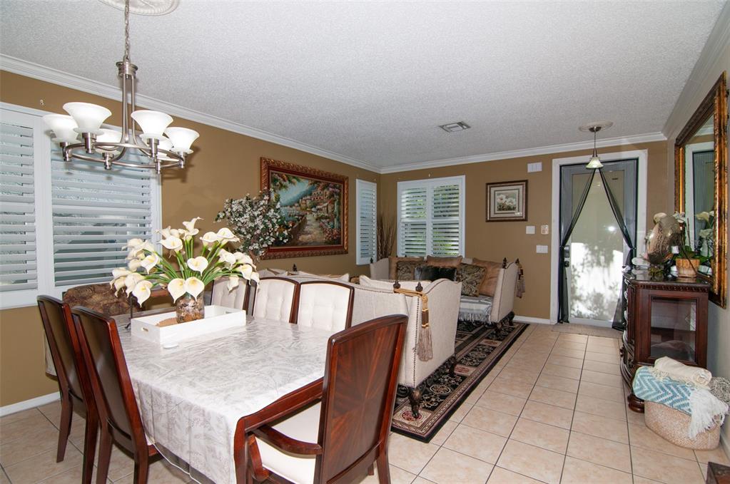A dining area with a table and chairs transitions into a living room with tile floors — 5124 SW 155TH AVENUE, MIRAMAR, FL