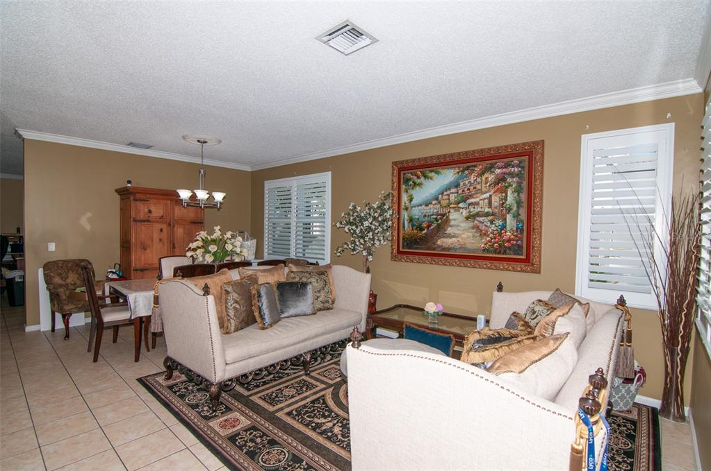 A living room features beige sofas, a patterned area rug, and a large framed landscape painting — 5124 SW 155TH AVENUE, MIRAMAR, FL