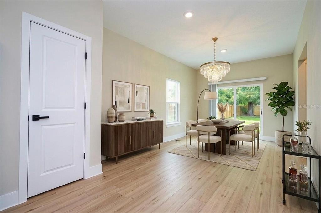 A dining room features a wooden table, upholstered chairs, a sideboard, and a crystal chandelier — 3449 W JEFFERSON STREET, ORLANDO, FL