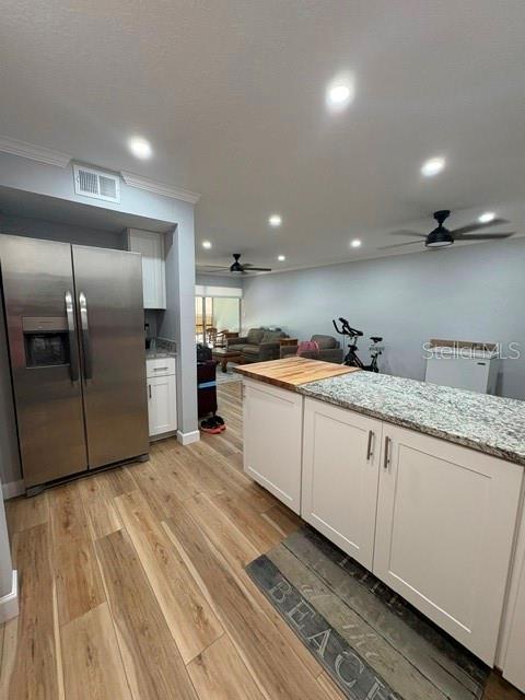 A kitchen with stainless steel appliances and a granite-topped island overlooks a living area — 2302 S MANHATTAN AVENUE UNIT 215, TAMPA, FL