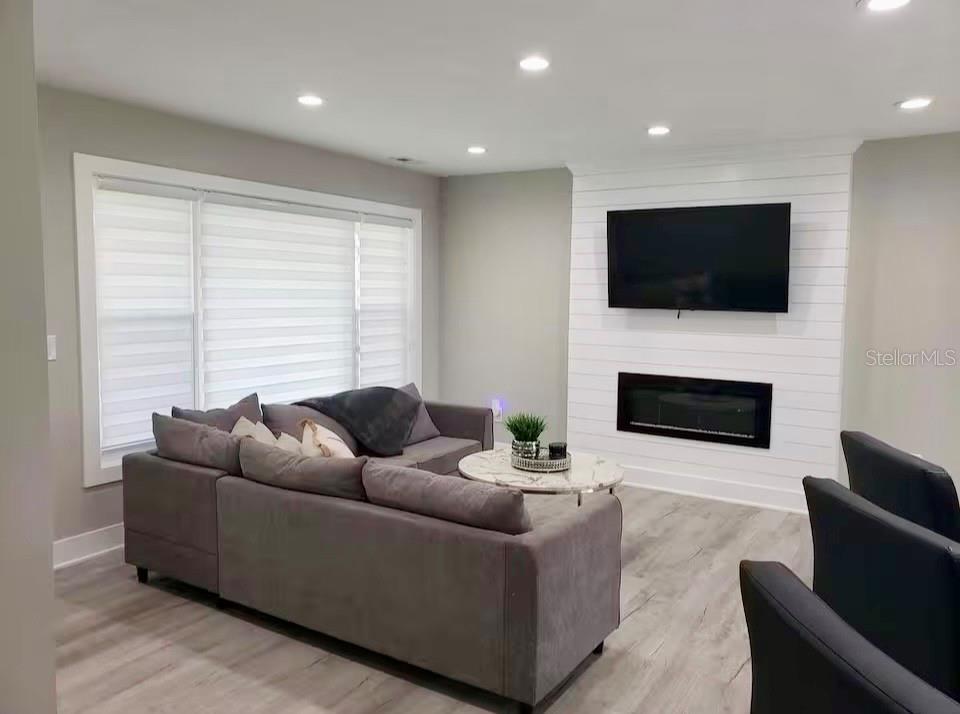 A living room features a grey sectional sofa, a fireplace, and a wall-mounted television — 1385 HARMONY DRIVE, PORT CHARLOTTE, FL