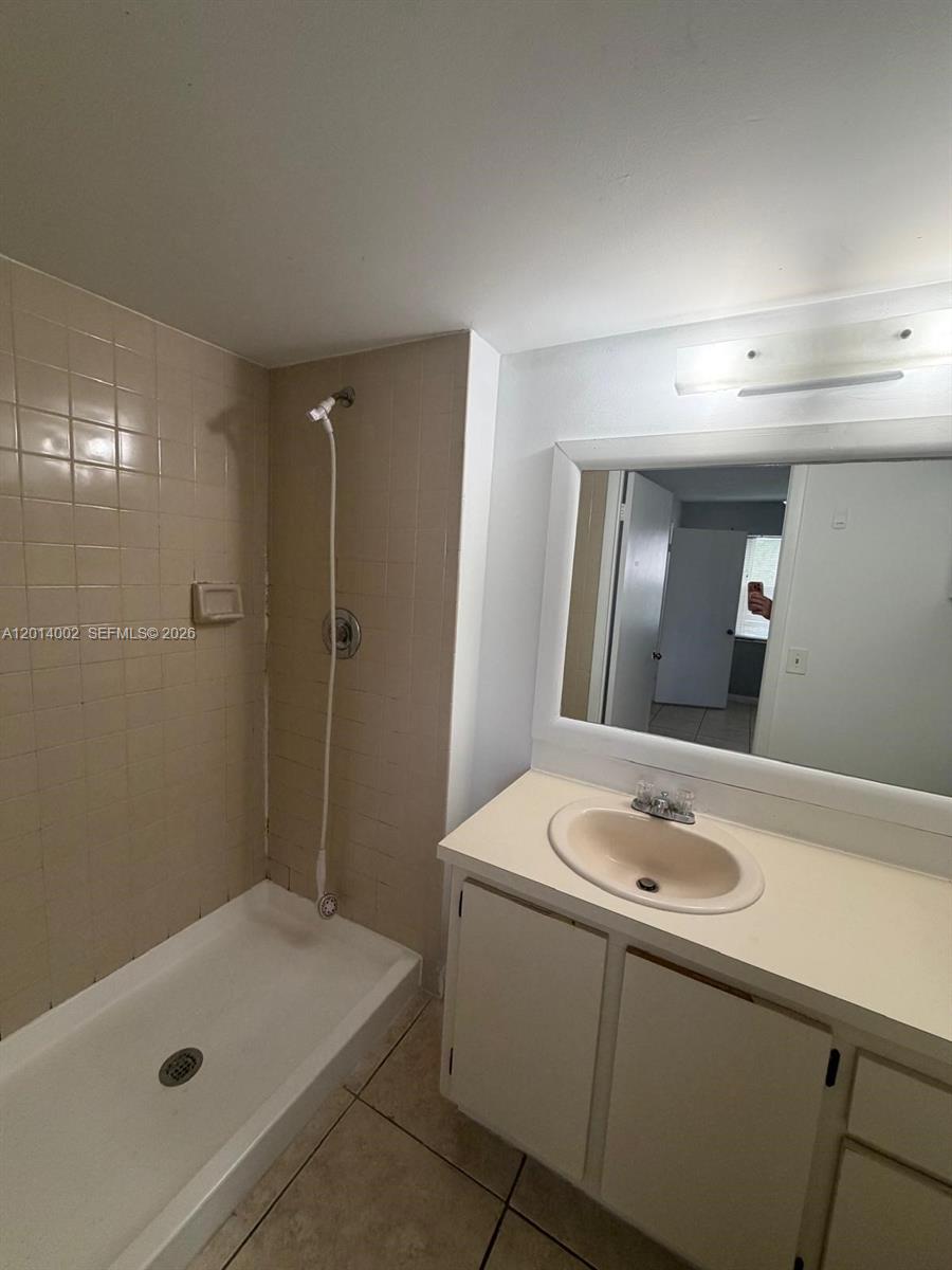 A bathroom features a walk-in shower with beige tile and a white vanity — 20825 NE 8th Ct # 19, Miami FL 33179, MIAMI, FL