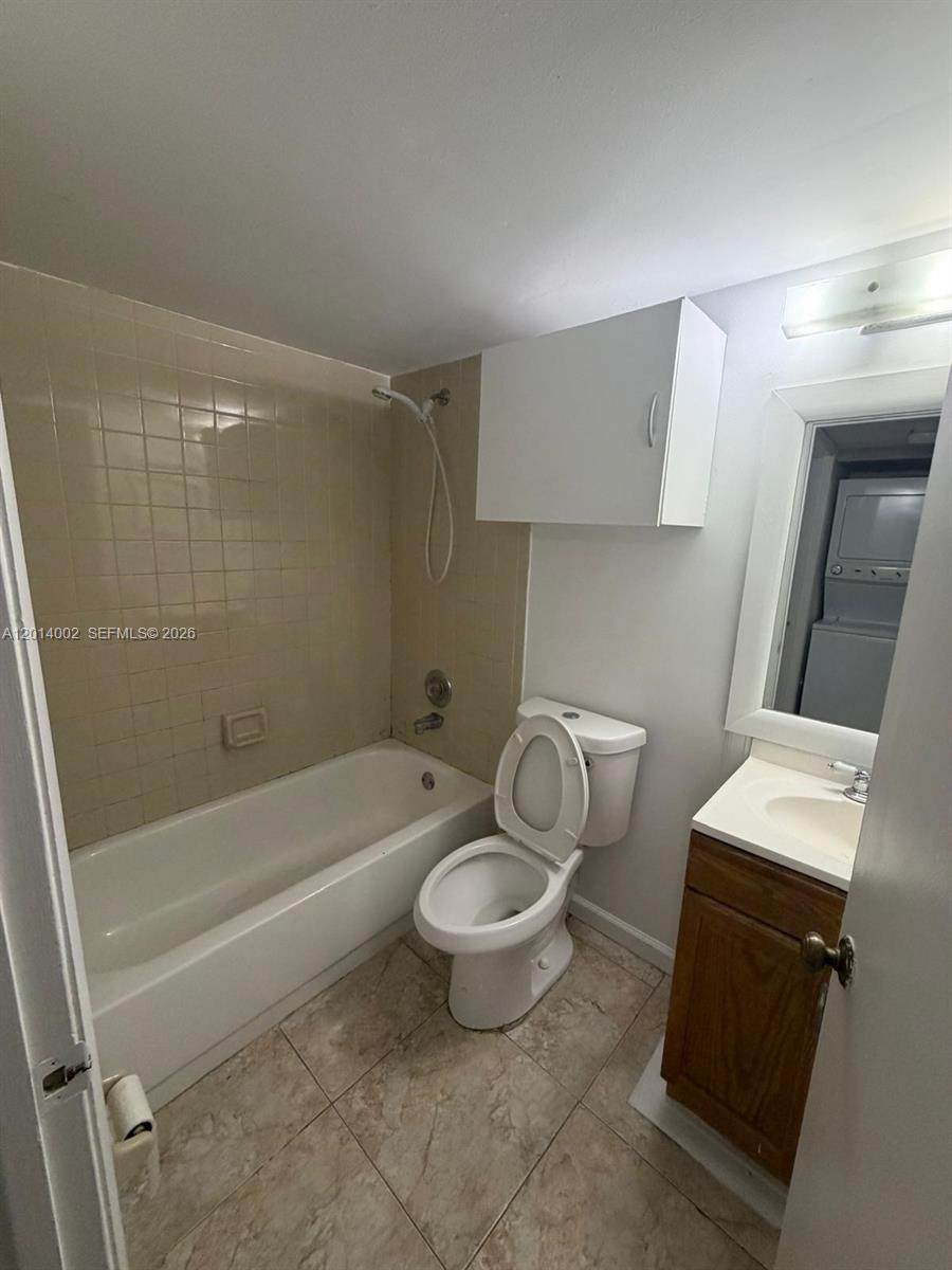 A bathroom features a beige tiled shower-tub combo, a white toilet, and a wooden vanity — 20825 NE 8th Ct # 19, Miami FL 33179, MIAMI, FL