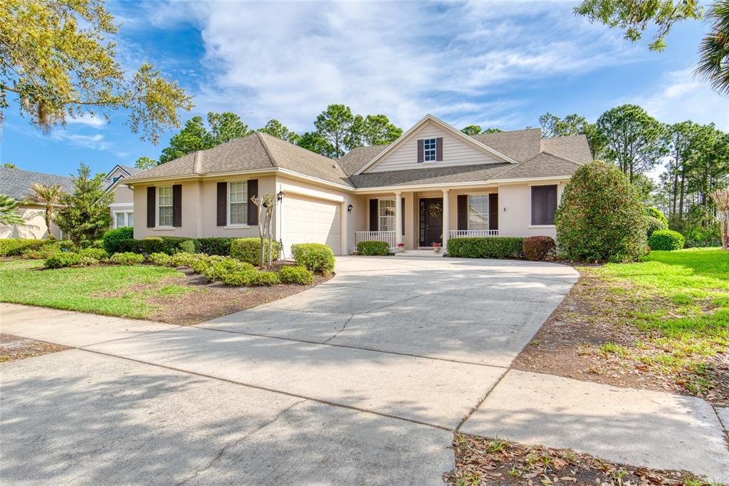 A single-story house with a beige exterior, a concrete driveway, and a front porch — 314 BELLINGRATH TERRACE, DELAND, FL