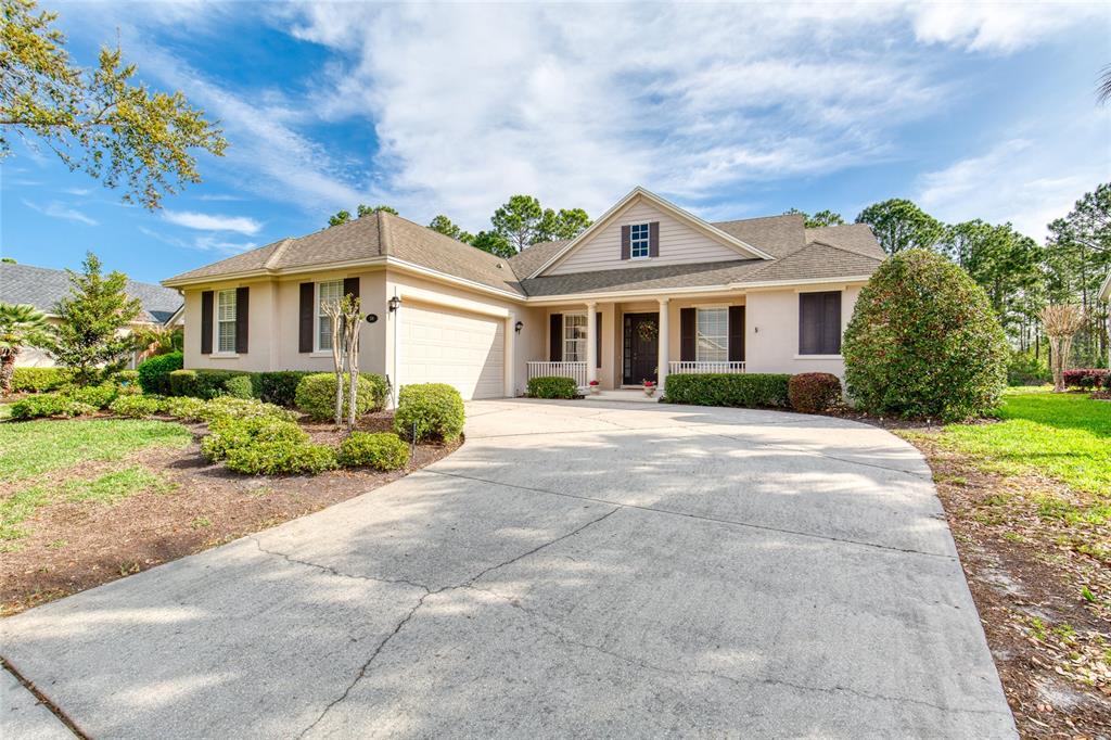 A single-story house with a beige exterior, a concrete driveway, and a two-car garage — 314 BELLINGRATH TERRACE, DELAND, FL