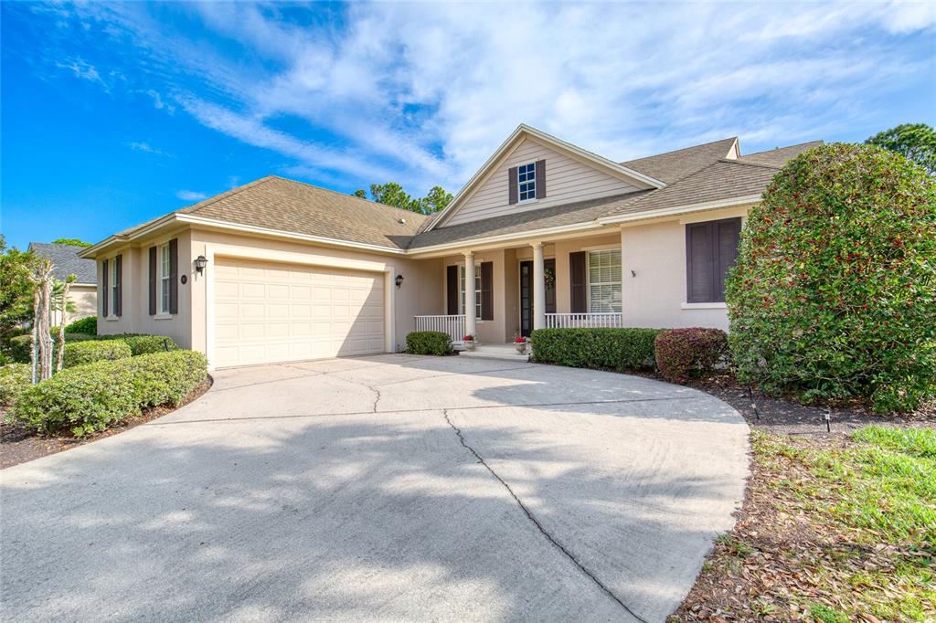 A single-story house with a beige exterior, a two-car garage, and a concrete driveway — 314 BELLINGRATH TERRACE, DELAND, FL