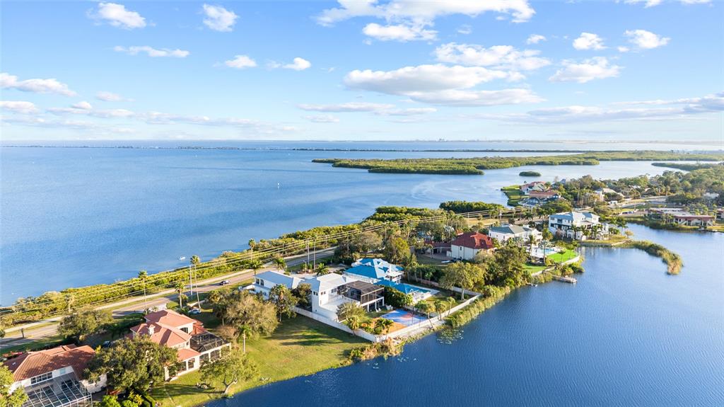 An aerial view shows several waterfront houses along a bay with mangroves in the distance — 951 S BAYSHORE BOULEVARD, SAFETY HARBOR, FL
