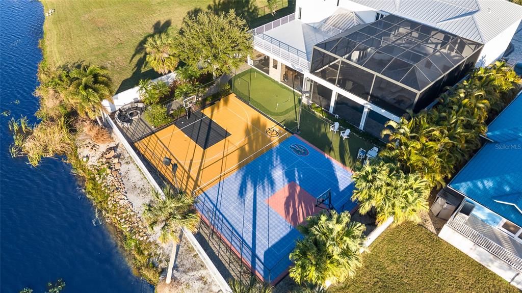 An aerial view shows a house with a screened pool, putting green, and sports court — 951 S BAYSHORE BOULEVARD, SAFETY HARBOR, FL