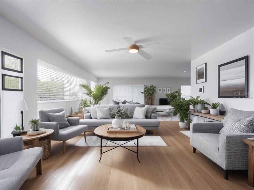 A living room features hardwood floors, a ceiling fan, and a mix of patterned seating — 717 W END CRESCENT N, LAKELAND, FL