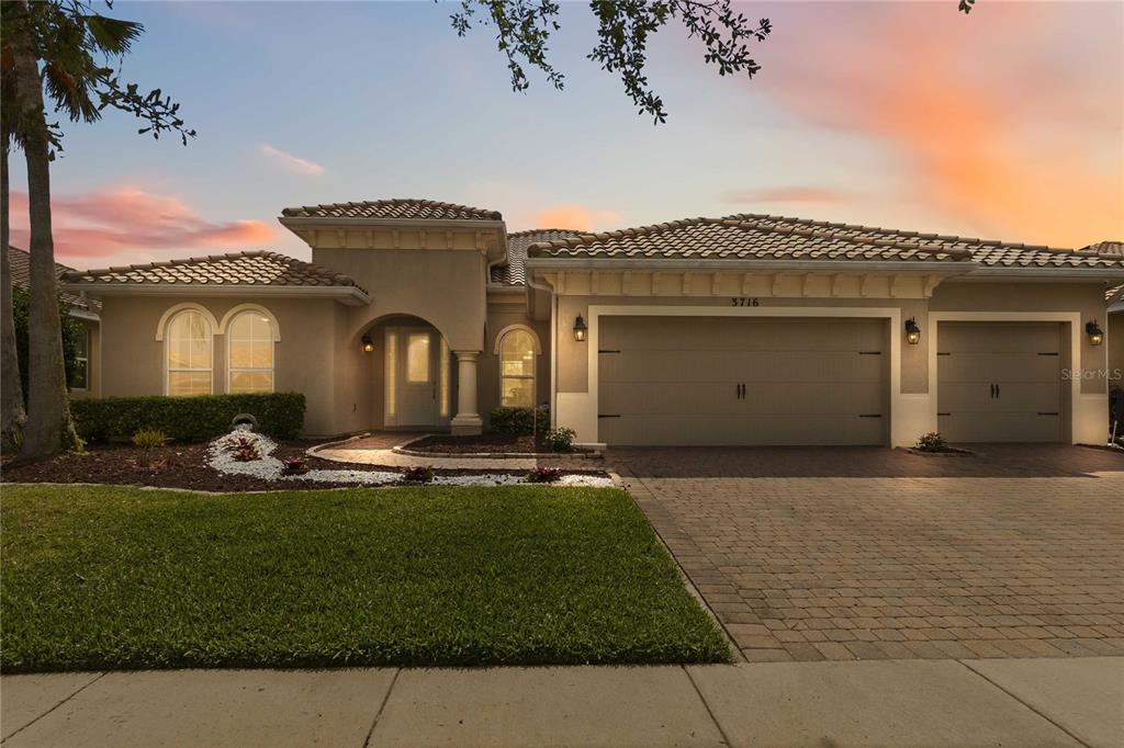 A single-story house with a beige stucco exterior, a tile roof, and a paved driveway — 3716 PARADISO CIRCLE, KISSIMMEE, FL