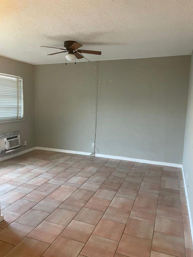 An empty room with tiled flooring, a ceiling fan, and a chain hanging from the ceiling — 702 N L Street # 13, FL 33460, FL