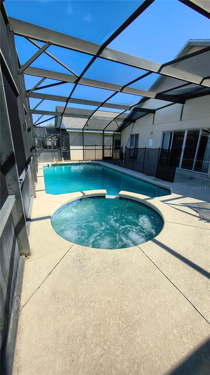 A screened-in patio features a swimming pool and a circular hot tub — 16721 S ROLLING GREEN DRIVE S, CLERMONT, FL