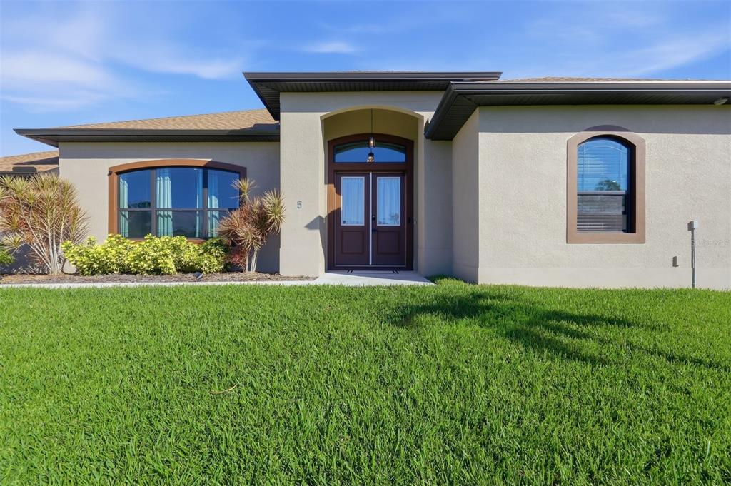 An aerial view shows a house with a brown roof, pool cage, and concrete driveway — 5 AYE COURT, PLACIDA, FL