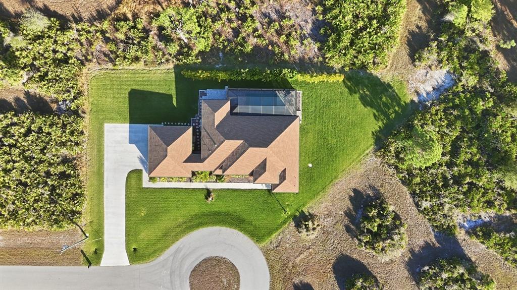 A single-story house with a tan stucco exterior, brown roof, and a front palm tree — 5 AYE COURT, PLACIDA, FL
