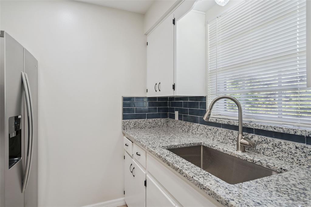 A living room features light wood-look flooring, a ceiling fan, and a kitchen pass-through window — 791 LAKE AVENUE UNIT 6, CLERMONT, FL