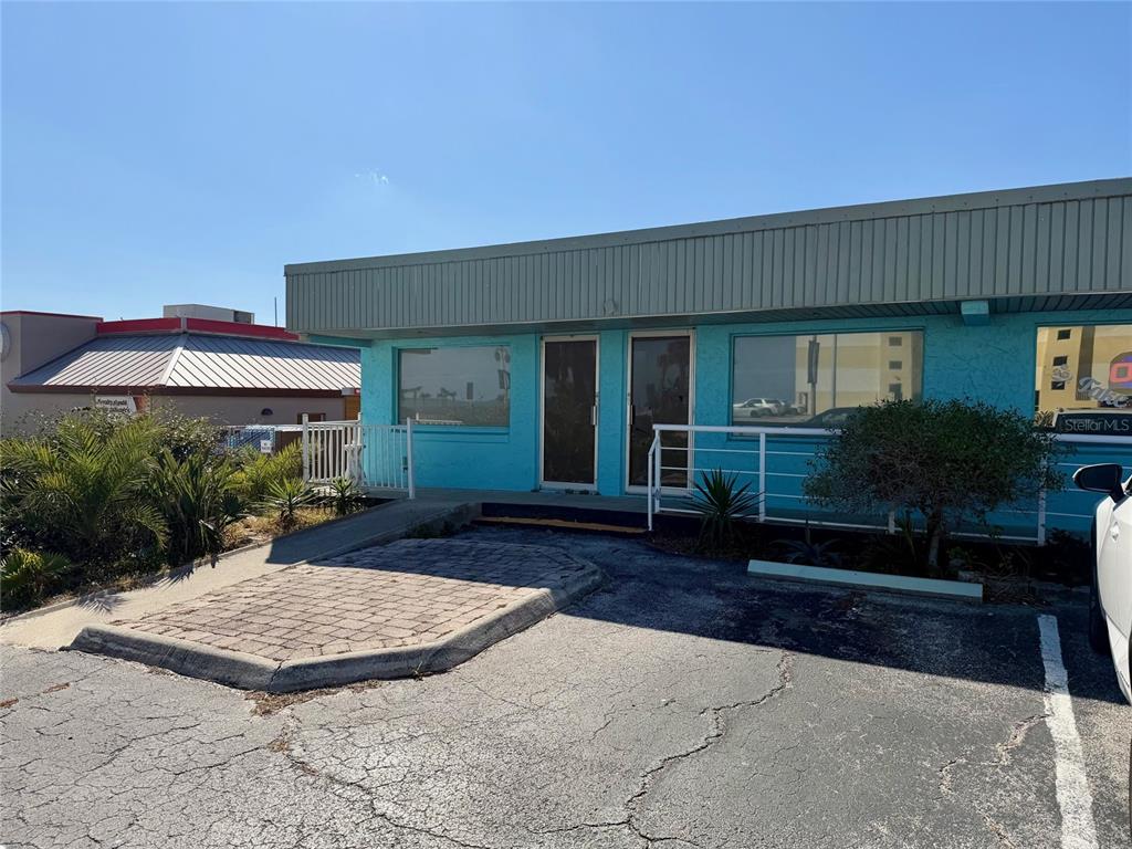 A single-story commercial building with a turquoise exterior, a paved ramp, and a parking lot — 3400 S ATLANTIC AVENUE UNIT 3416, DAYTONA BEACH, FL