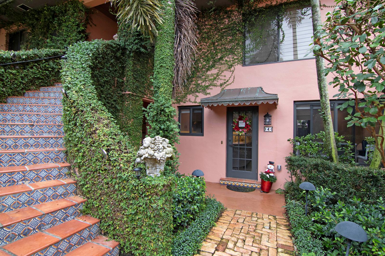 A pink stucco building exterior features a tiled staircase, a brick walkway, and climbing ivy — 226 Chilean Avenue # 4, Palm Beach FL 33480, PALM BEACH, FL