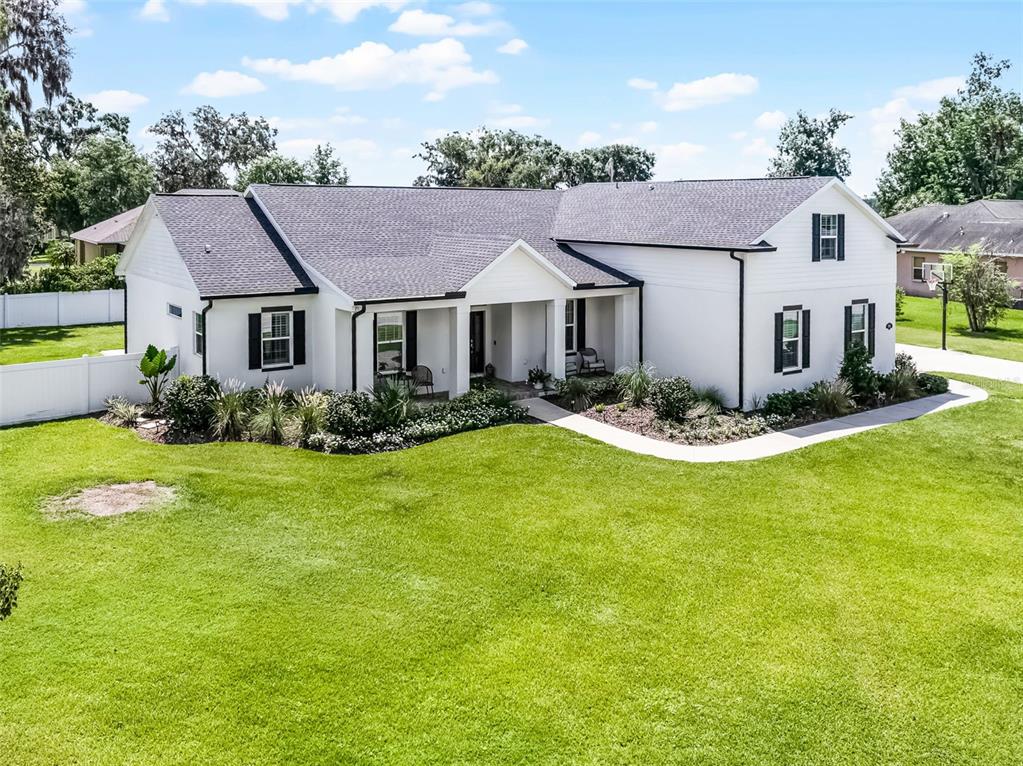 A white single-story house with a dark shingled roof and black shutters sits on grass — 926 JOHN CRESSLER DRIVE, SEFFNER, FL
