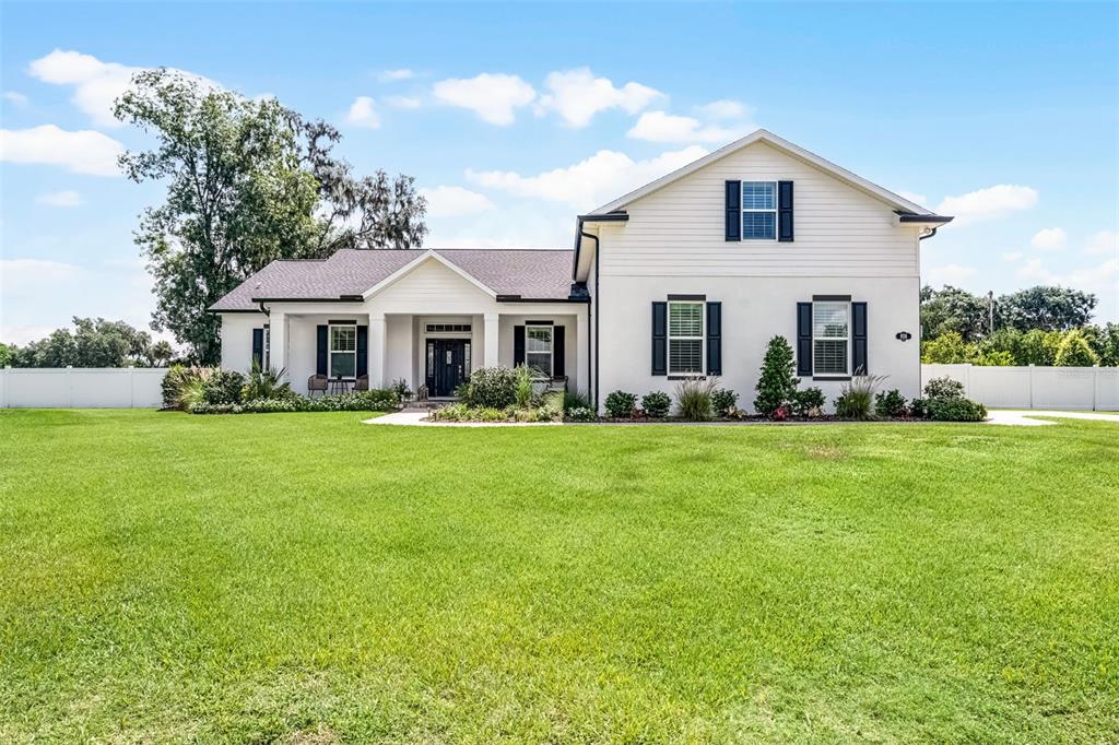 A two-story white house with black shutters sits on a large, grassy lawn — 926 JOHN CRESSLER DRIVE, SEFFNER, FL