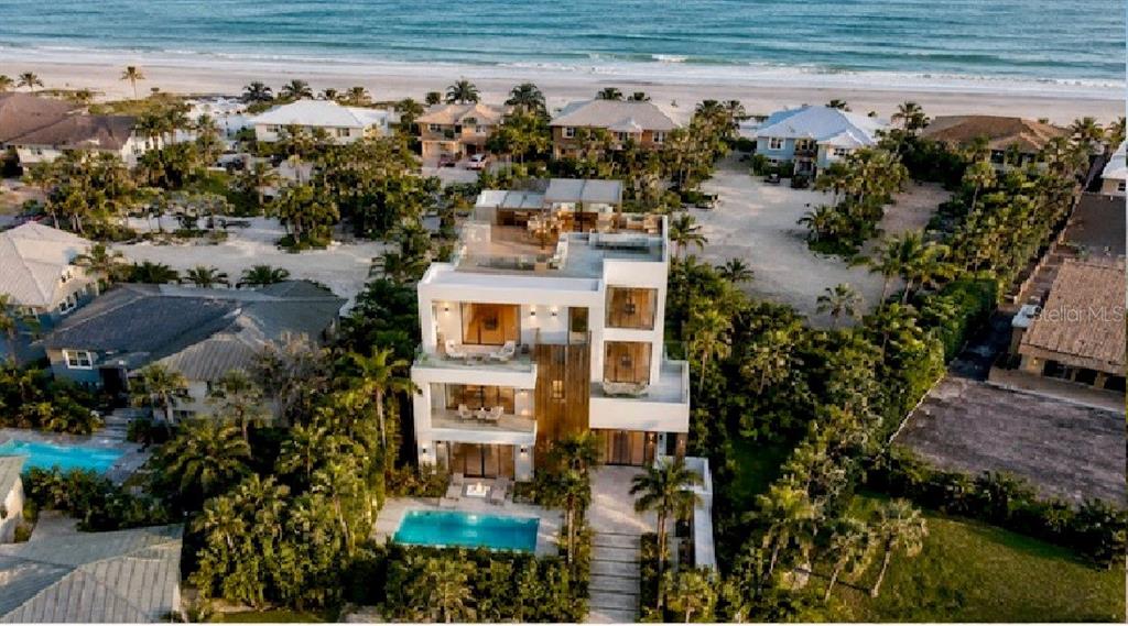 An aerial view of a modern three-story beachfront home with a swimming pool and rooftop deck — 4732 VAN KLEECK DRIVE, NEW SMYRNA BEACH, FL