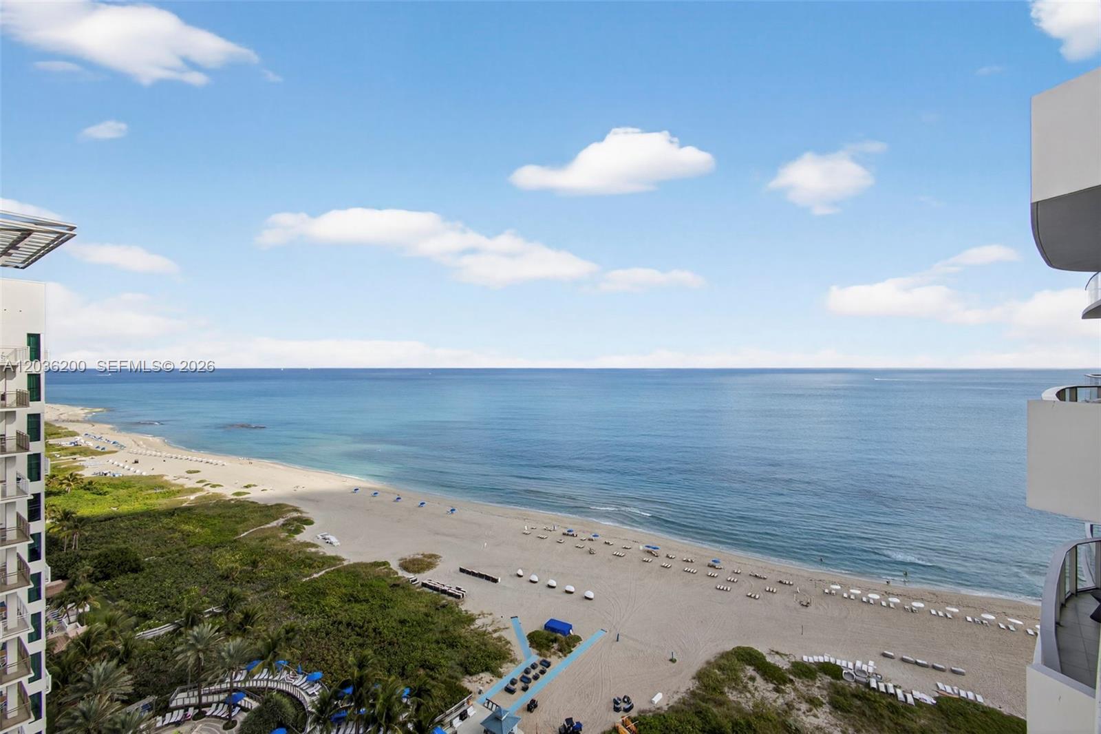 An elevated view shows a sandy beach, ocean, and clear sky from a balcony — 3100 N Ocean Dr # 1801, Singer Island FL 33404, SINGER ISLAND, FL