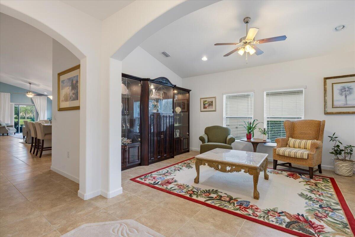 A living room features a floral rug, a marble coffee table, and a dark cabinet — 2024 Albany Terrace SW, Vero Beach FL 32968, VERO BEACH, FL