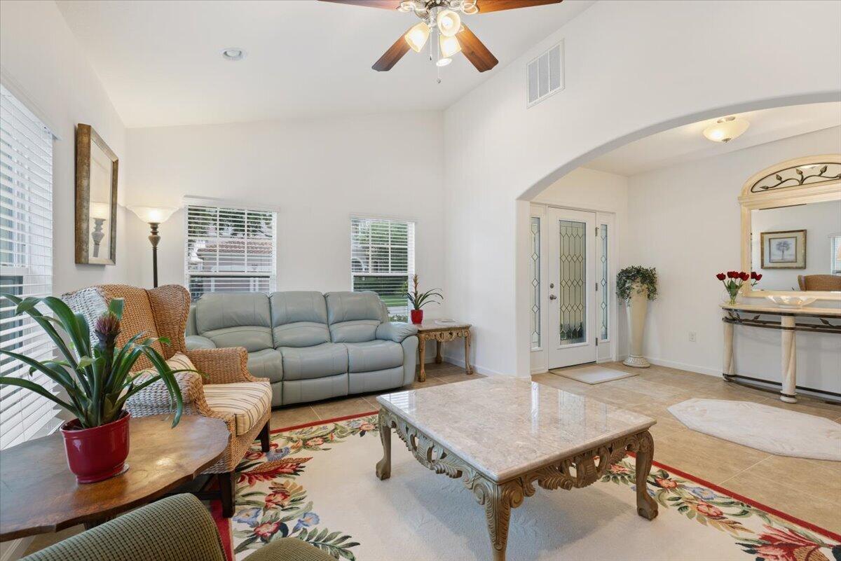 A living room features a light blue sofa, a marble coffee table, and a floral rug — 2024 Albany Terrace SW, Vero Beach FL 32968, VERO BEACH, FL