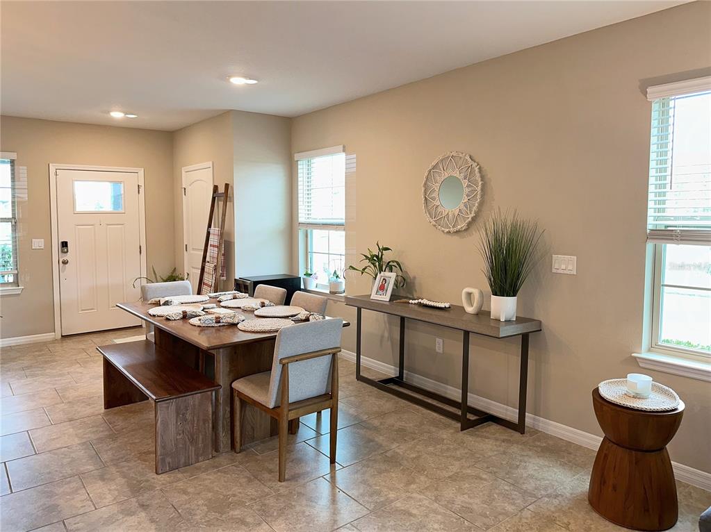 A dining area features a wooden table with a bench, chairs, and a console table — 10126 SALT POINT DRIVE, WINTER GARDEN, FL