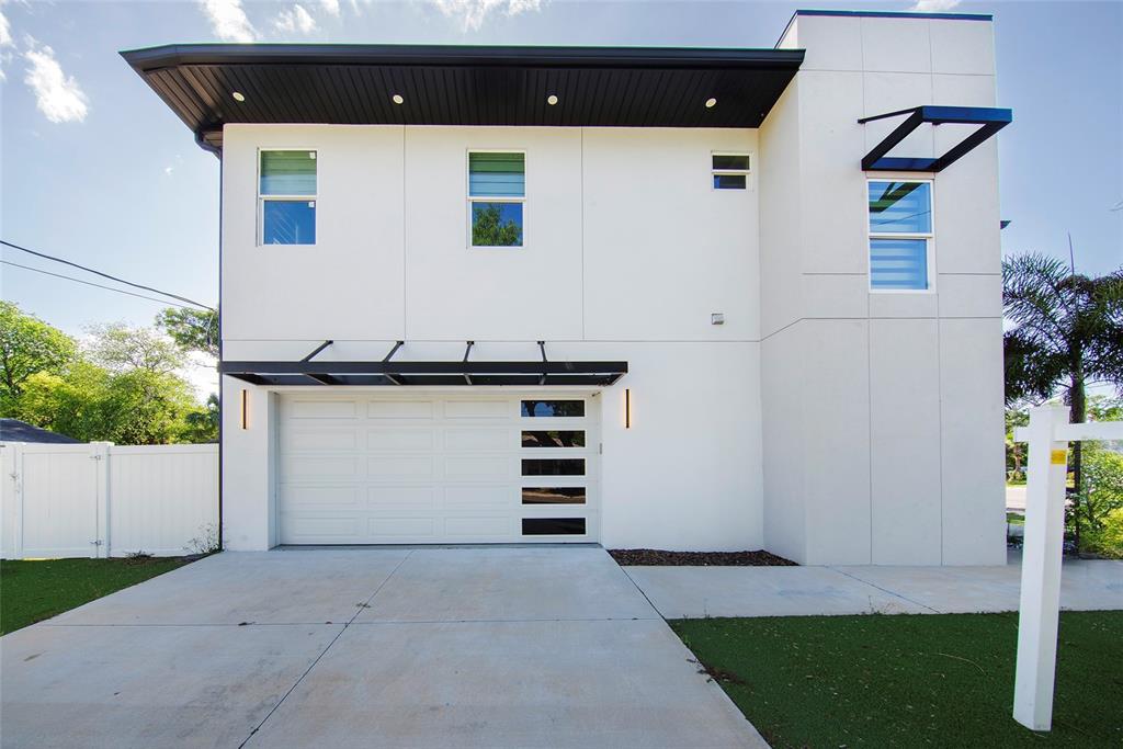 A modern two-story house features a white stucco exterior, a flat roof, and a garage — 902 W SLIGH AVENUE, TAMPA, FL