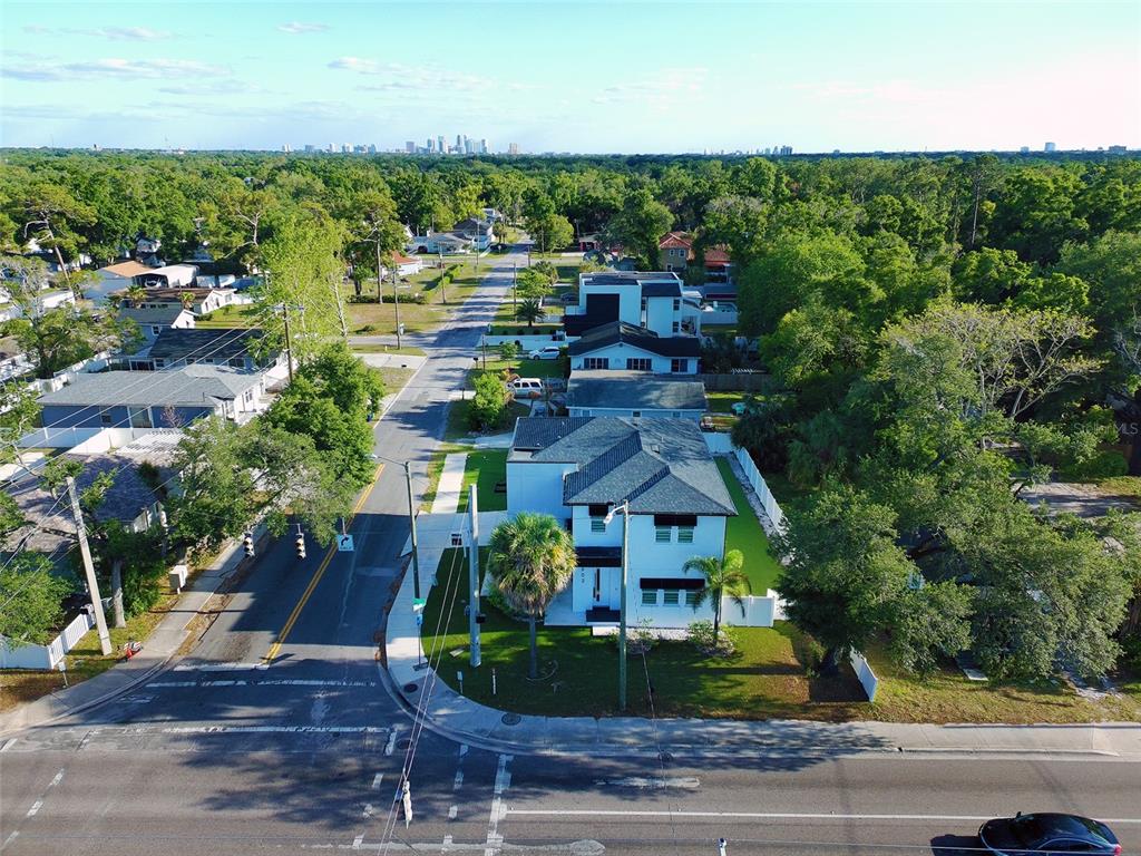 An aerial view shows a modern white house on a corner lot near trees — 902 W SLIGH AVENUE, TAMPA, FL