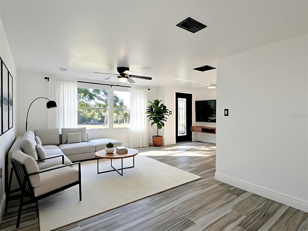 A living room features a sectional sofa, a round coffee table, and wood-look tile flooring — 15217 BAILEY HILL ROAD, BROOKSVILLE, FL