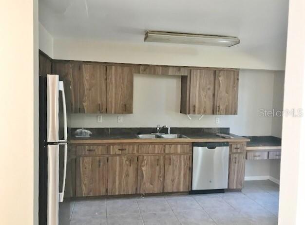 A kitchen features wood-grain cabinets, a stainless steel dishwasher, and a refrigerator — 4139 OLD ROAD 37, LAKELAND, FL