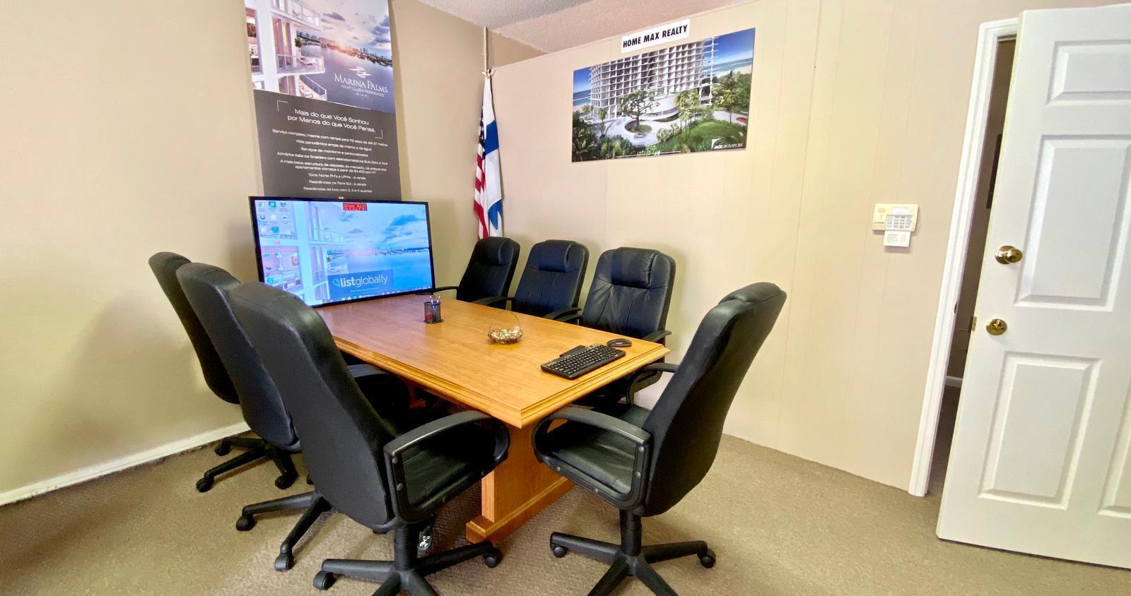 A conference room features a wooden table, six black chairs, and wall-mounted real estate posters — 934 S Dixie Highway # 934, Lantana FL 33462, LANTANA, FL