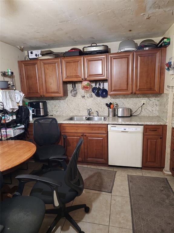 A kitchen features wood cabinets, a double sink, a dishwasher, and a round dining table — 3539 COLLEEN DRIVE, LAKELAND, FL