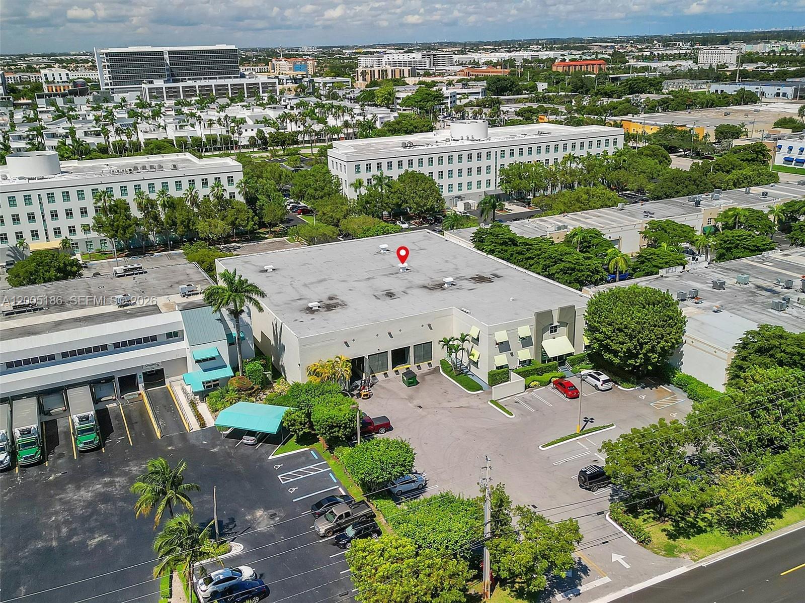 An aerial view shows a commercial building with a flat roof and surrounding parking lots — 8299 NW 30th Ter, Doral FL 33122, DORAL, FL