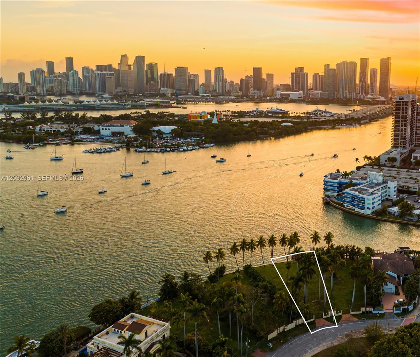 An aerial view shows a vacant waterfront lot outlined in white near a city skyline — 1228 S Venetian Way, Miami FL 33139, MIAMI, FL