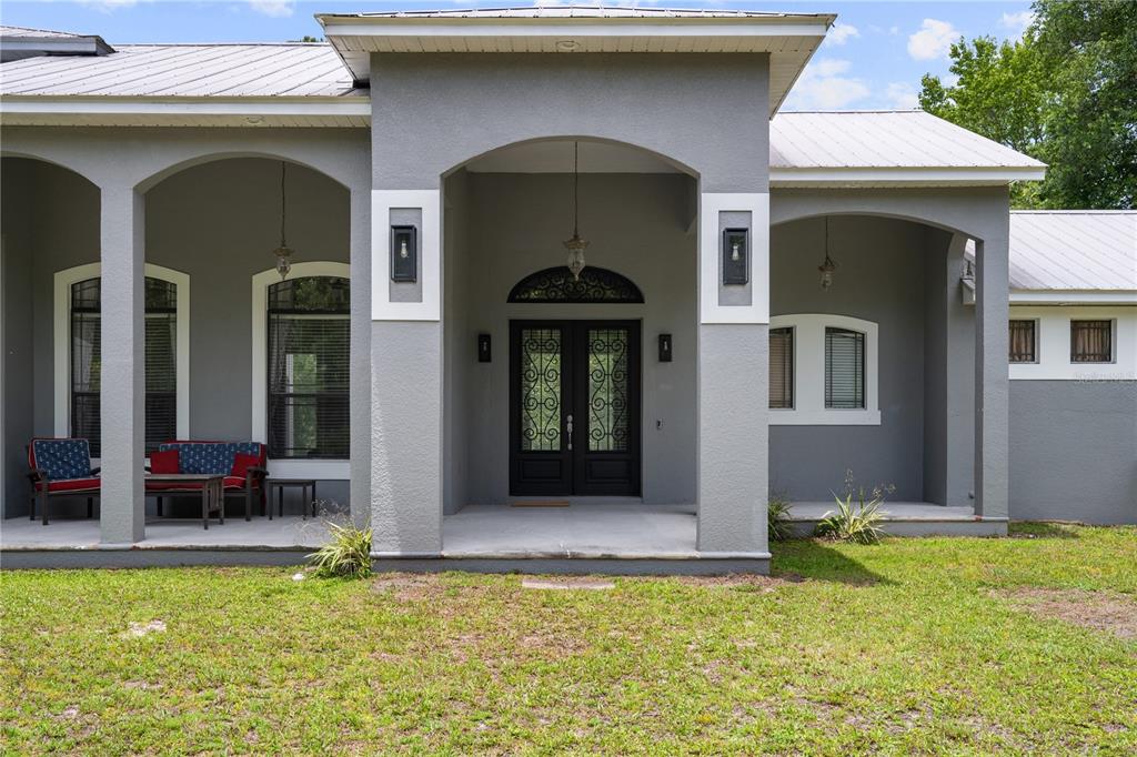 A gray house exterior features a covered front porch with arched openings and double doors — 5920 EDGERTON AVENUE, ORLANDO, FL