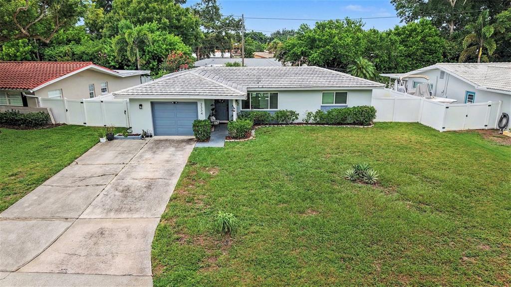 A single-story house with a gray roof, blue garage door, and a concrete driveway — 2334 TUDOR LANE, CLEARWATER, FL