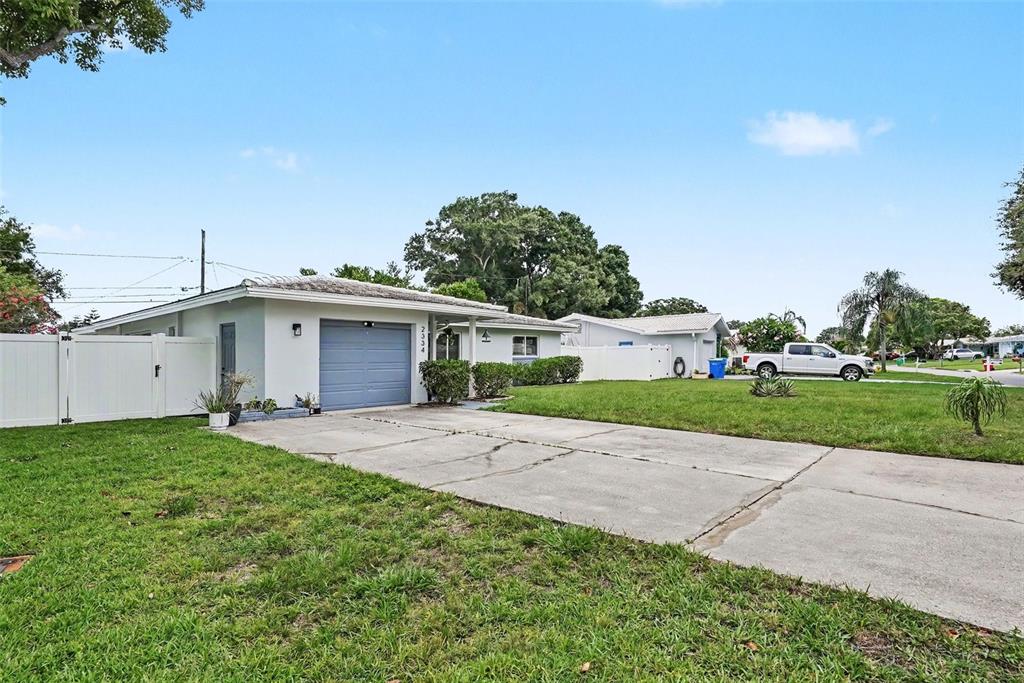 A single-story house with a blue garage door and a concrete driveway — 2334 TUDOR LANE, CLEARWATER, FL
