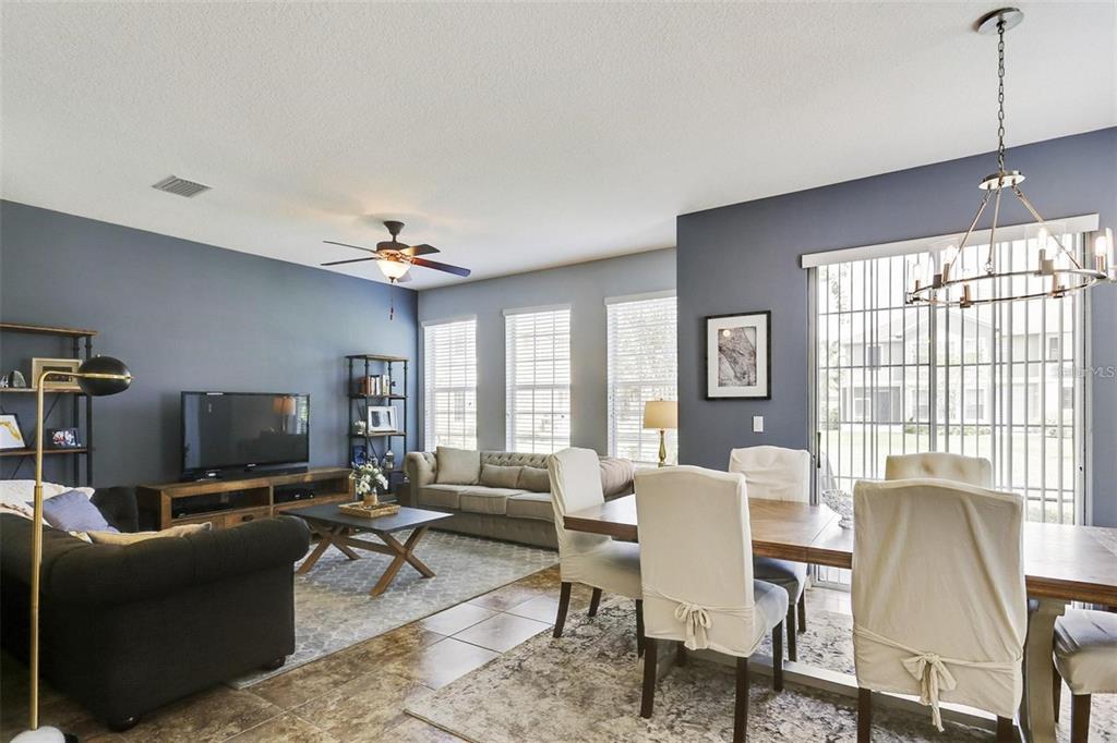 A living and dining area features blue walls, tile flooring, and a large sliding glass door — 7001 INTERBAY BOULEVARD UNIT 257, TAMPA, FL