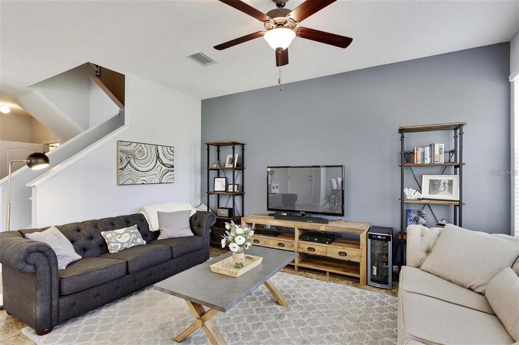 A living room features a dark gray sofa, a light sofa, and a television console — 7001 INTERBAY BOULEVARD UNIT 257, TAMPA, FL