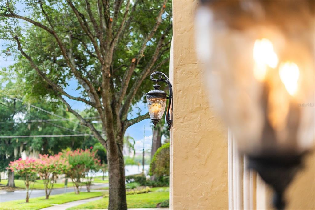 A wall-mounted outdoor lantern is attached to a stucco pillar near a tree-lined street — 1830 GERDA TERRACE, ORLANDO, FL