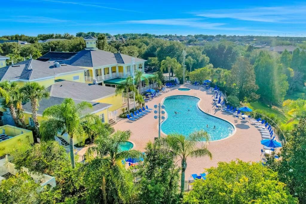 An aerial view shows a community swimming pool and clubhouse surrounded by lush green trees — 903 GRAN BAHAMA BOULEVARD UNIT 903, DAVENPORT, FL