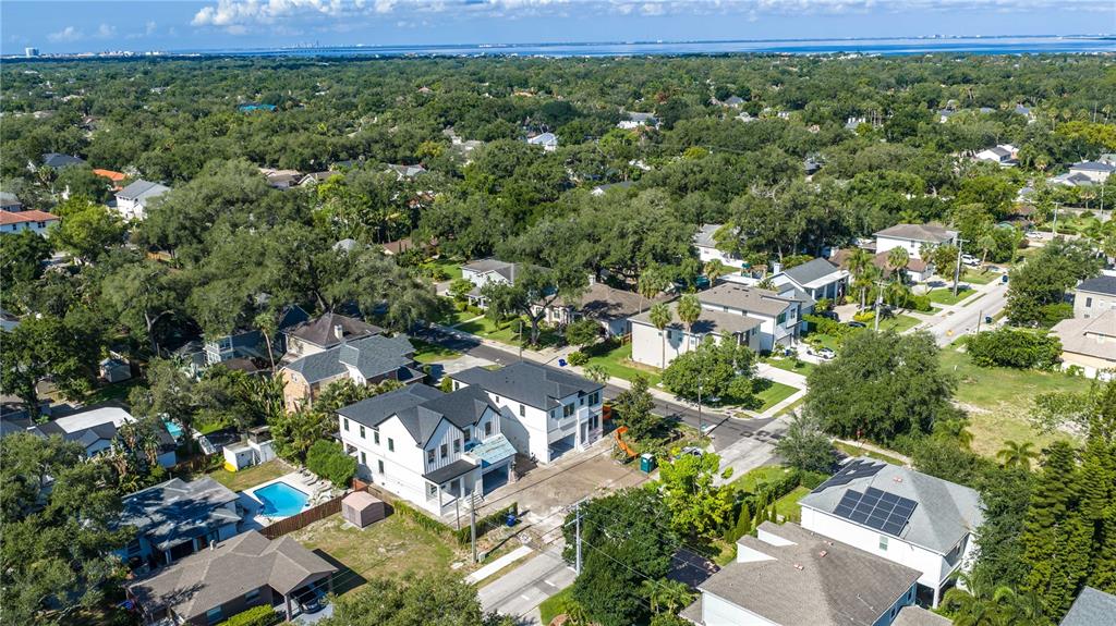 An aerial view shows several suburban houses with dark roofs surrounded by lush green trees — 4018 W CLEVELAND STREET, TAMPA, FL