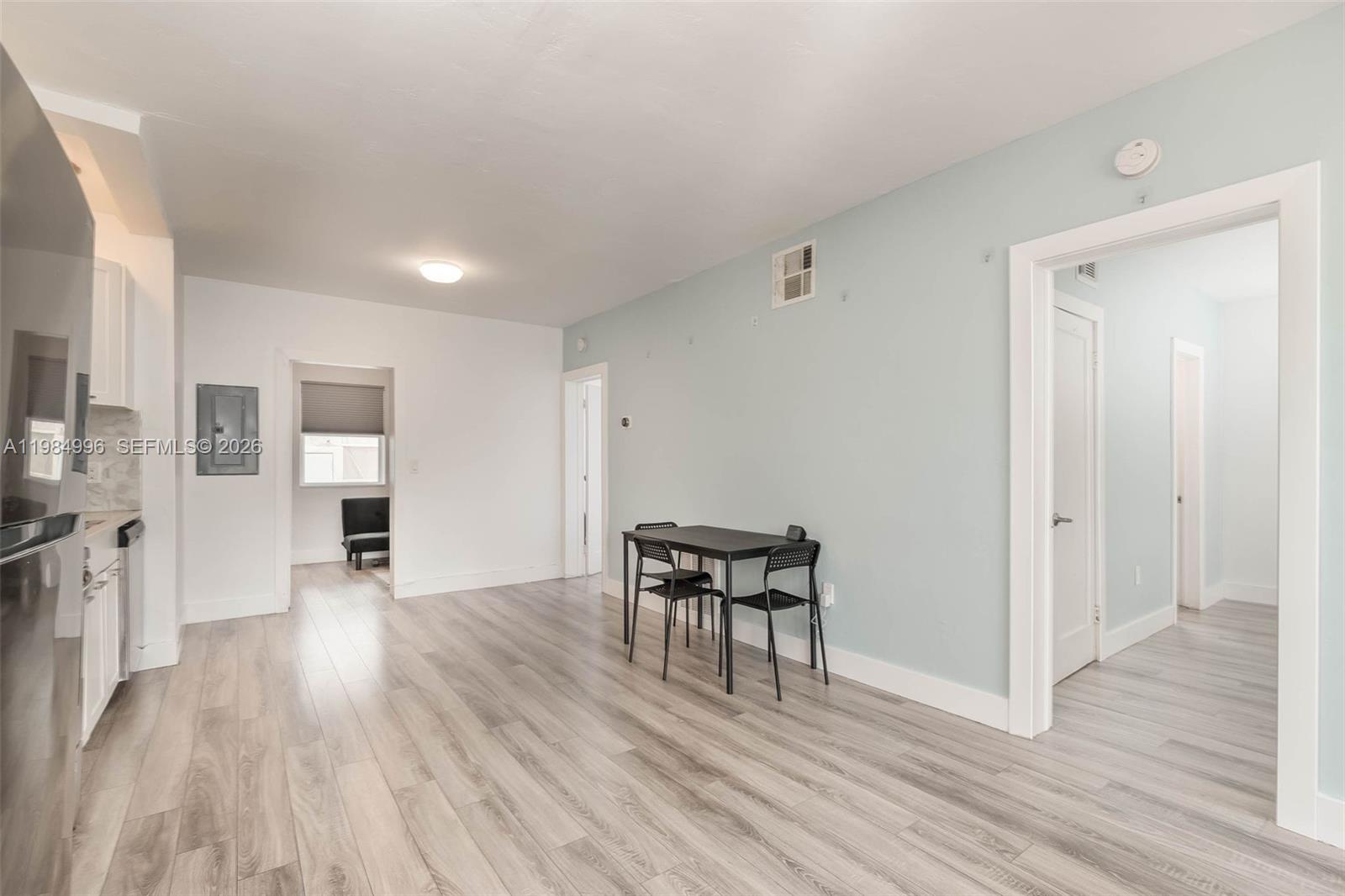 A dining area with a small black table and chairs sits against a light blue wall — 1275 Marseille Dr # 35, Miami Beach FL 33141, MIAMI BEACH, FL