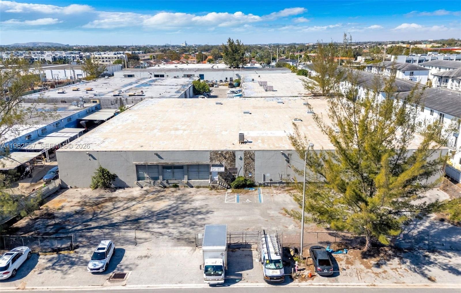 An aerial view of a flat-roofed industrial warehouse building with an adjacent parking lot — 7620 W 2nd Ct, Hialeah FL 33014, HIALEAH, FL